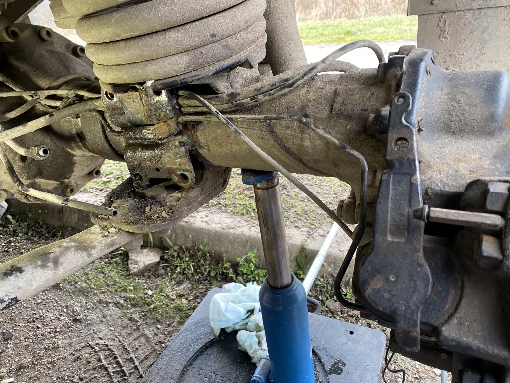 Close-up view of a vehicle's suspension and axle assembly, showing detailed components such as the shock absorber, springs, and connecting rods.