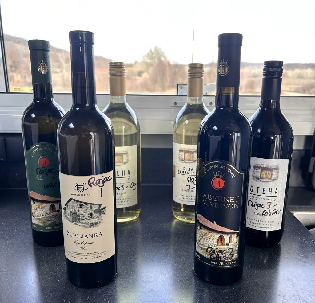 A selection of wine bottles displayed on a countertop, including a bottle labeled 'Župljanka' and various white and red wines from a winery.
