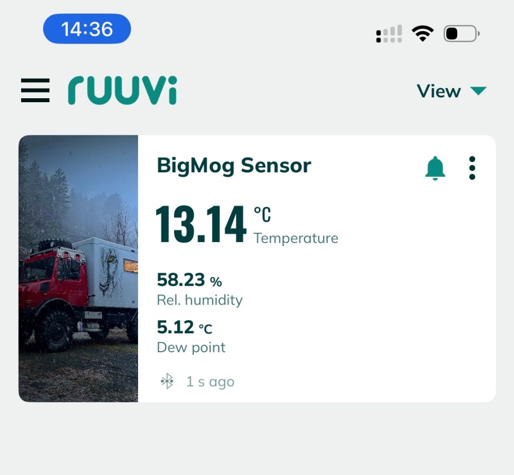 Display showing Ruuvi sensor readings for BigMog, including temperature of 13.14 °C, relative humidity of 58.23%, and dew point of 5.12 °C, with a background image of a truck in a forest.