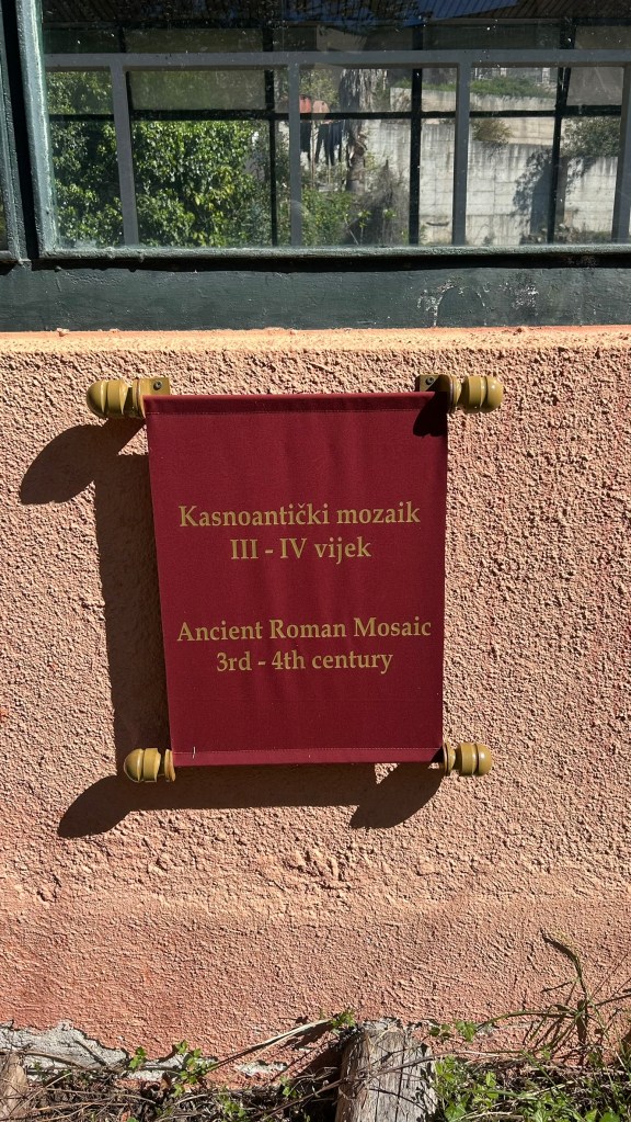 A sign displaying information about an ancient Roman mosaic, dating from the 3rd to 4th century, with inscriptions in both Croatian and English.