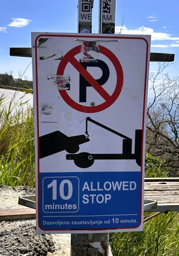 A parking sign featuring a 'no parking' symbol, indicating a 10-minute stopping limit, with additional text in a foreign language.